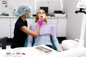 Female dentist treating her patient teeth